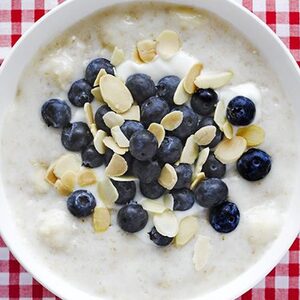 Creamy yogurt porridge with banana, blueberry & almond topping